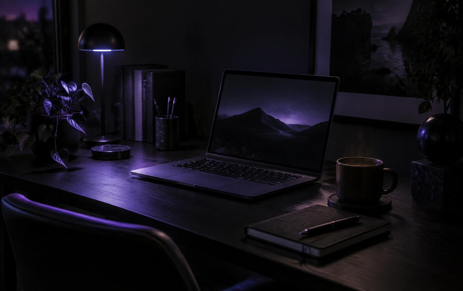 A dark studio desk lit by a lamp with soft violet light